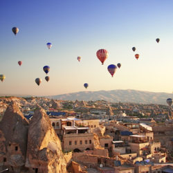 Sunrise in Cappadocia, Turkey, with balloons and typical fairy chimney